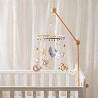 Wooden ocean-themed baby mobile rattle with hanging sea creatures and stars, attached to a white crib.