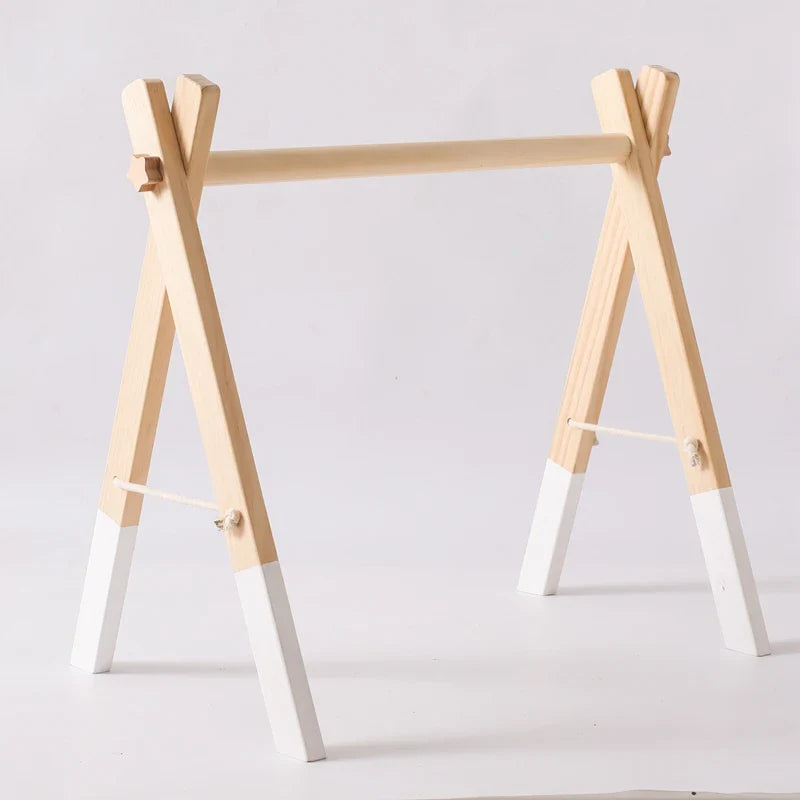 Foldable Montessori wooden baby gym frame with natural wood and white painted legs.