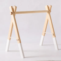 Foldable Montessori wooden baby gym frame with natural wood and white painted legs.