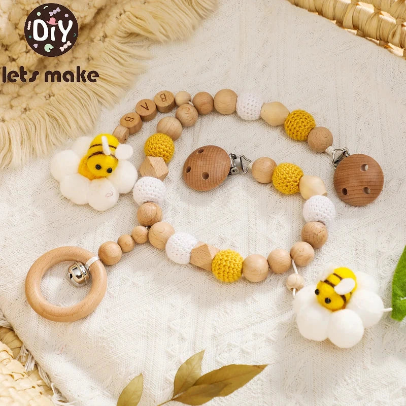 Natural wooden animal rattle and teether toy with crochet beads and plush bee accents for sensory and teething relief.