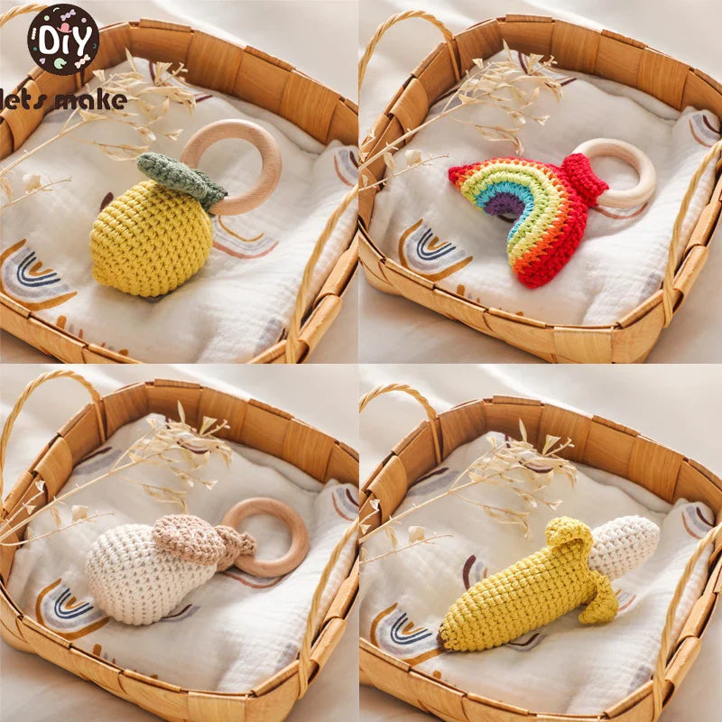 Set of four crochet baby rattle toys with wooden rings in fruit and animal shapes, placed in woven baskets.